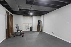 Workout area with dark flooring and baseboards