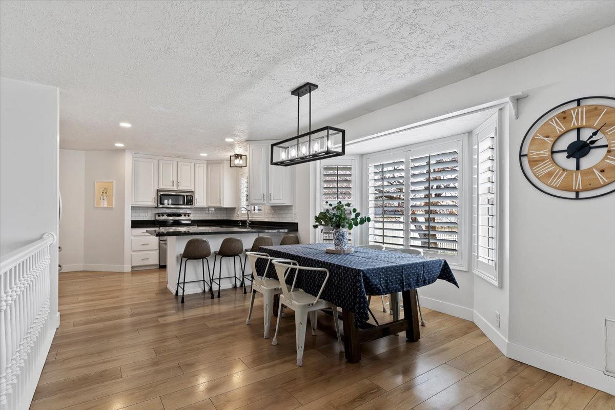 Dining area featuring light wood finished floors, recessed lighting, and a textured ceiling