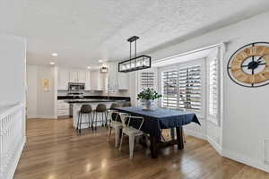 Dining area featuring light wood finished floors, recessed lighting, and a textured ceiling