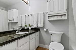 Bathroom featuring curtained shower, vanity, and wood finished floors