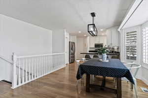 Dining space featuring recessed lighting, light wood-style flooring, and a textured ceiling