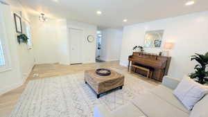 Open living area featuring light wood-finish flooring and recessed lighting