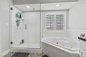 Full bath featuring a shower stall, a jetted tub, a textured ceiling, recessed lighting, and tile patterned flooring