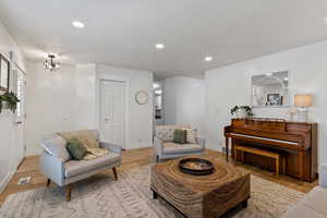 Living room with recessed lighting, light wood-style floors, and a textured ceiling