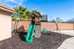 View of playground with a fenced backyard