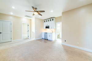 Unfurnished living room featuring light carpet, ceiling fan, and recessed lighting