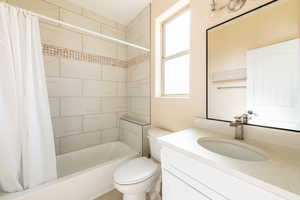 Full bath with shower / tub combo with curtain and vanity