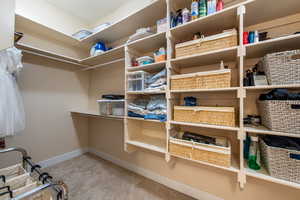 Walk in closet featuring light carpet