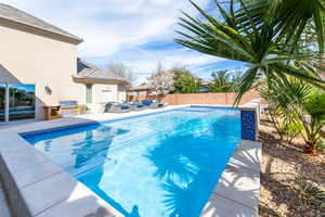 View of swimming pool featuring outdoor lounge area, a fenced backyard, patio surround, and area for grilling