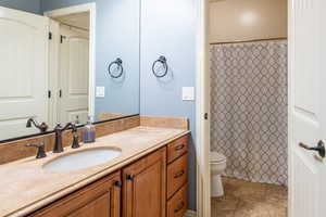 Full bath featuring curtained shower and vanity