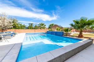 View of swimming pool featuring a fenced backyard and patio surround