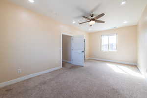 Empty room with light colored carpet, a ceiling fan, and recessed lighting