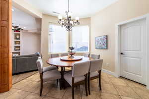 Dining space with hanging lights and light tile patterned flooring