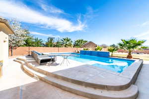 View of swimming pool with patio surround and a fenced backyard