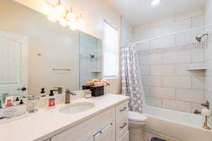 Bathroom with vanity and shower / tub combo with curtain