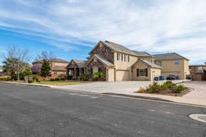 View of front facade featuring a residential view, stucco siding, stone siding, an attached garage, and concrete driveway