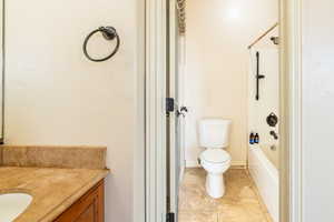 Full bath featuring vanity, washtub / shower combination, and light tile patterned flooring
