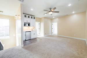 Kitchen featuring white cabinetry, glass fronted cabinets, light countertops, open floor plan, and recessed lighting