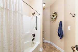Bathroom featuring shower / bath combo and a textured ceiling