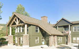 View of front of home with a balcony, a chimney, and board and batten siding