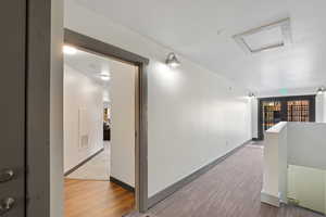 Corridor with carpet flooring, an upstairs landing, and wood finished floors