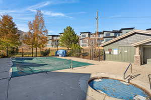 Community pool with a patio, a hot tub, and a residential view