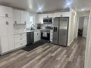 Kitchen featuring stainless steel appliances, white cabinetry, dark wood finished floors, decorative backsplash, and recessed lighting