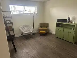 Living area with dark wood-style floors and baseboards