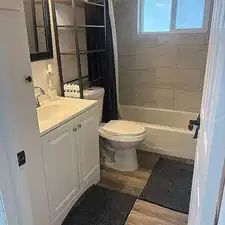 Full bath with vanity, shower / bath combo with shower curtain, and light wood-style flooring