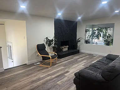 Living area with wood finished floors, a fireplace, and recessed lighting