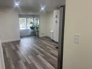 Spare room with dark wood-type flooring and baseboards