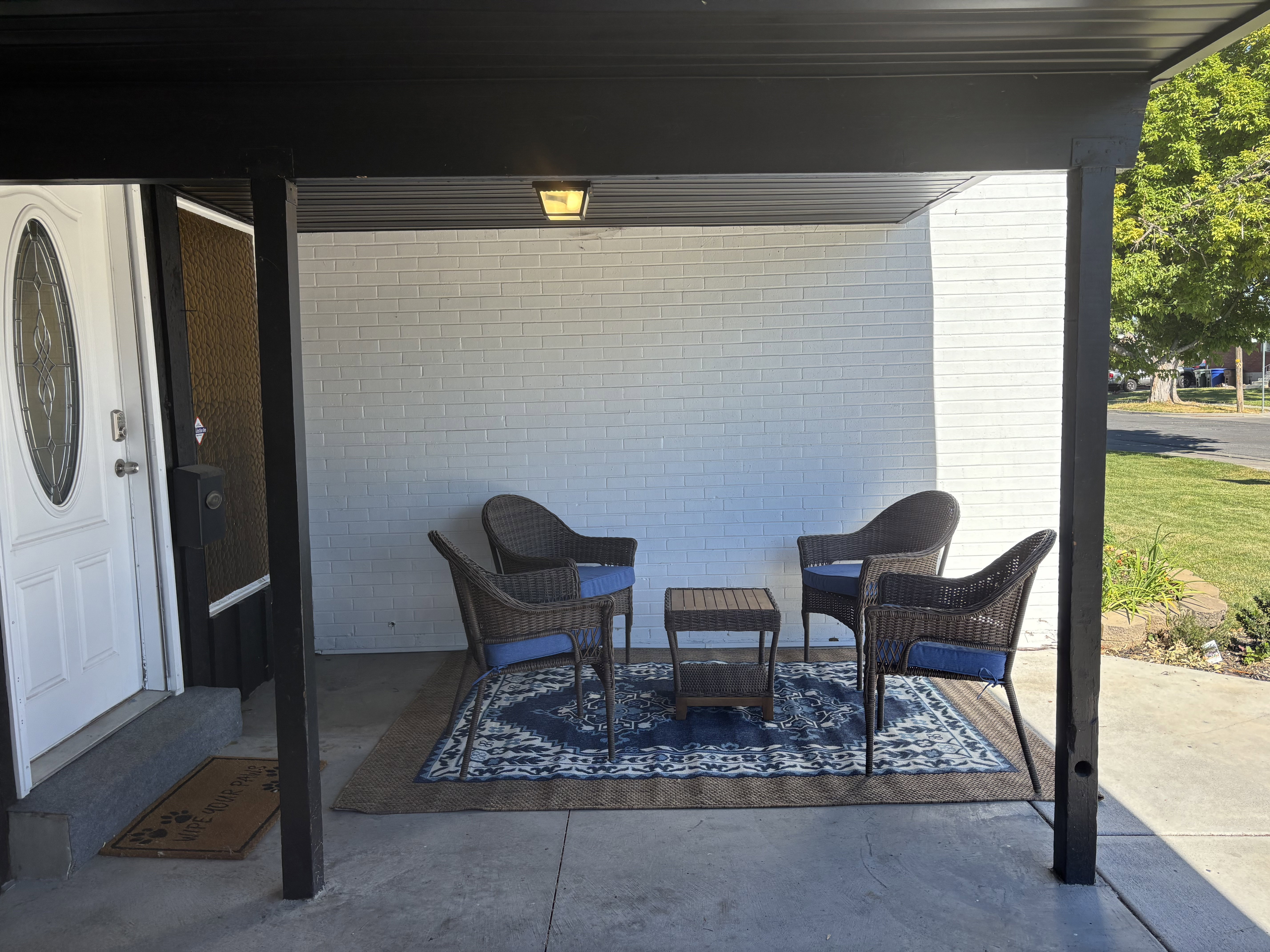 Covered concrete porch with white brick exterior
