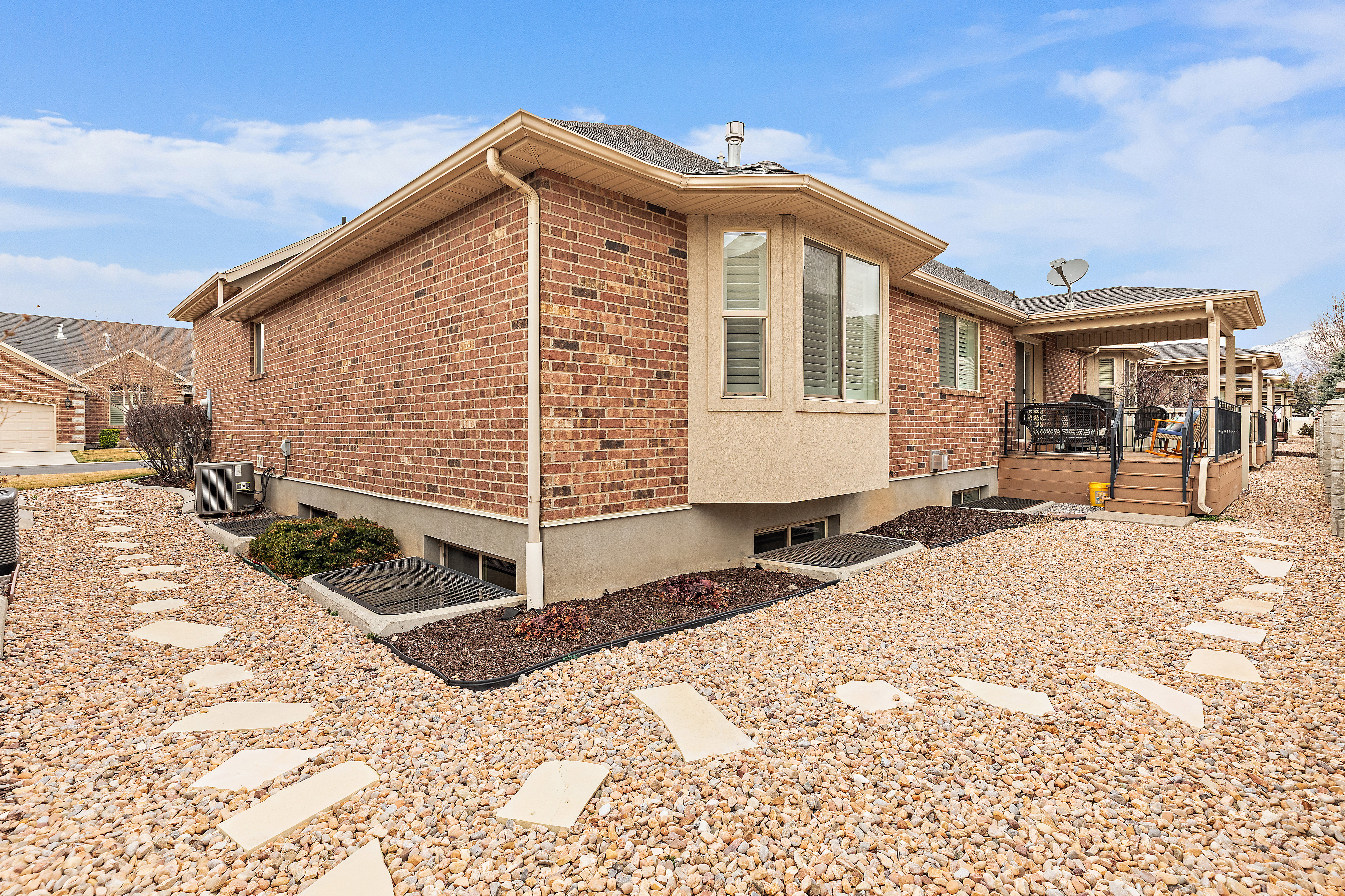 View of home's exterior featuring a wooden deck and brick siding
