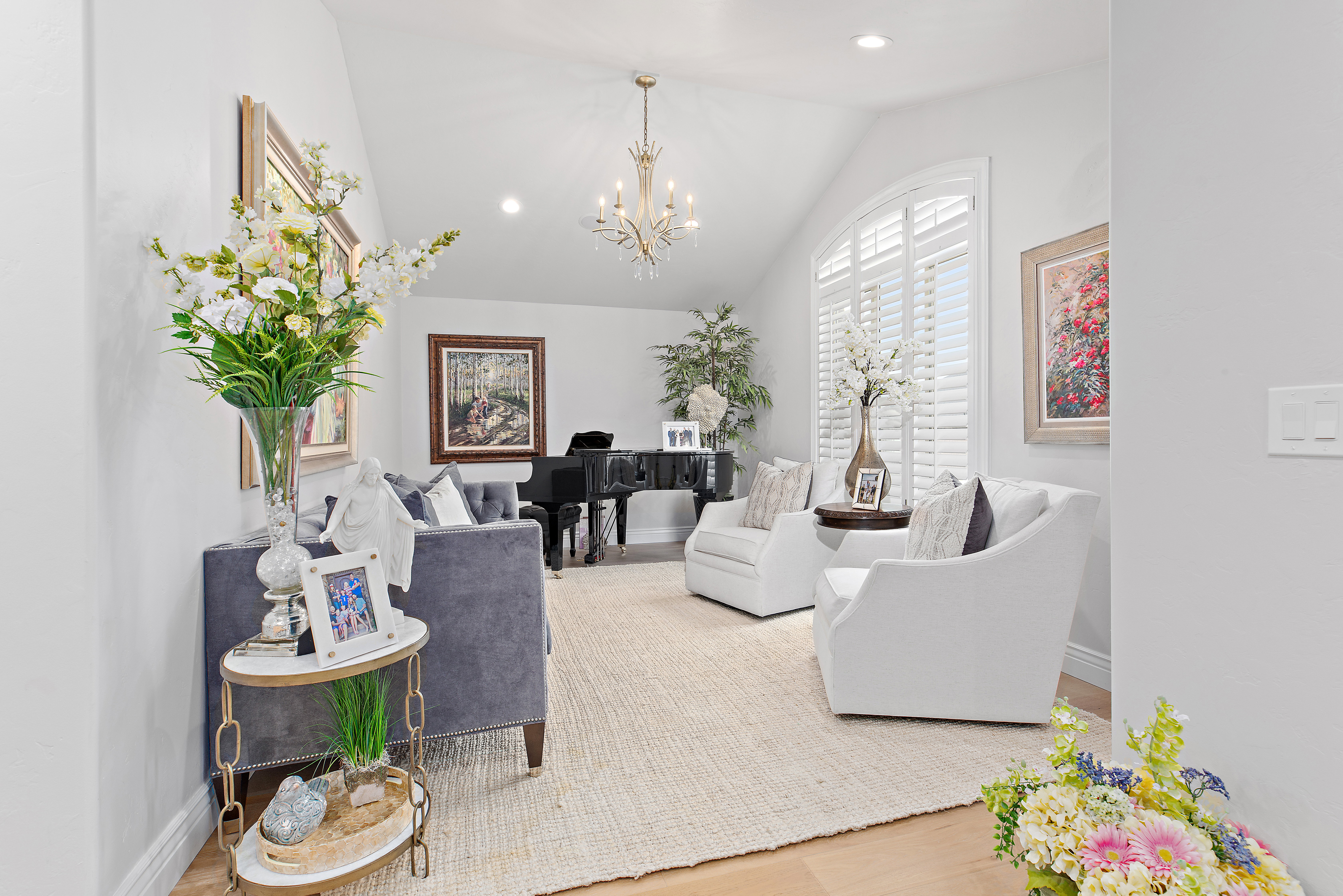 Living room featuring wood finished floors, vaulted ceiling, and suspended lighting