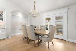 Dining room featuring hanging lights, light wood finished floors, and lofted ceiling