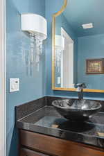 Bathroom with vanity and a textured wall