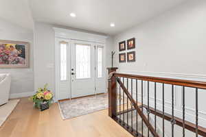 Foyer entrance with light wood-style floors and recessed lighting