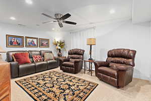 Living area with recessed lighting, a ceiling fan, and light carpet