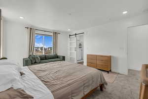 Bedroom featuring a barn door, carpet flooring, and recessed lighting