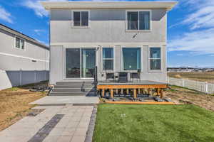 Rear view of property with a fenced backyard, stucco siding, and a deck
