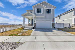 Craftsman inspired home featuring board and batten siding, a mountain view, stone siding, driveway, and a garage