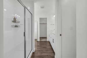 Full bathroom featuring vanity, dark wood-style flooring, and a stall shower