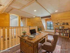 Virtually Staged Loft/Office featuring wood walls, dark wood finished floors, recessed lighting, and vaulted ceiling