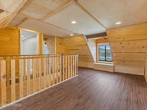 Additional living space featuring wood walls, dark wood-type flooring, recessed lighting, and vaulted ceiling