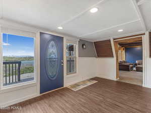 Foyer entrance with dark wood-style floors, a wainscoted wall, and recessed lighting