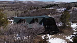 View of front of house with a gambrel roof, a mountain view, and a balcony