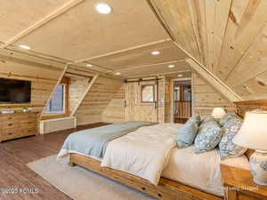 Virtually Staged Bedroom with wood walls, recessed lighting, wood finished floors, and lofted ceiling