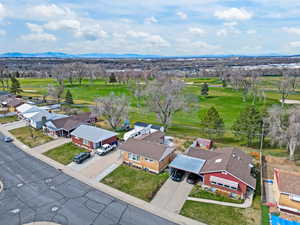 Aerial view of residential area featuring a golf club and a mountain backdrop