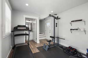 Workout room featuring dark wood-style flooring and recessed lighting