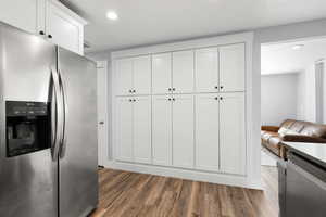 Kitchen with stainless steel appliances, recessed lighting, white cabinetry, and dark wood-style flooring